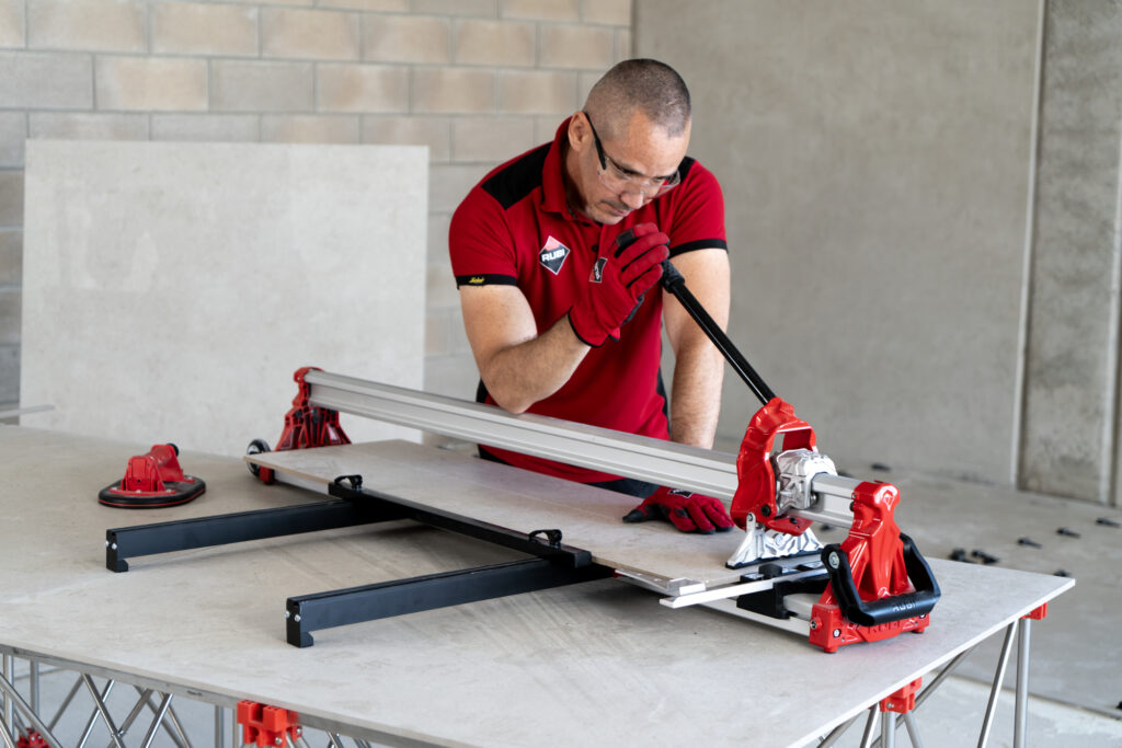Professional tiler using an RCH to cut a long tile.