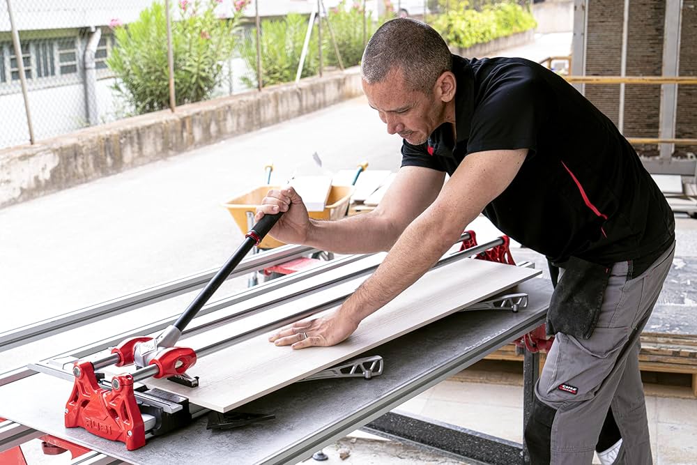 Professional using a manual cutter to cut a large format tile.