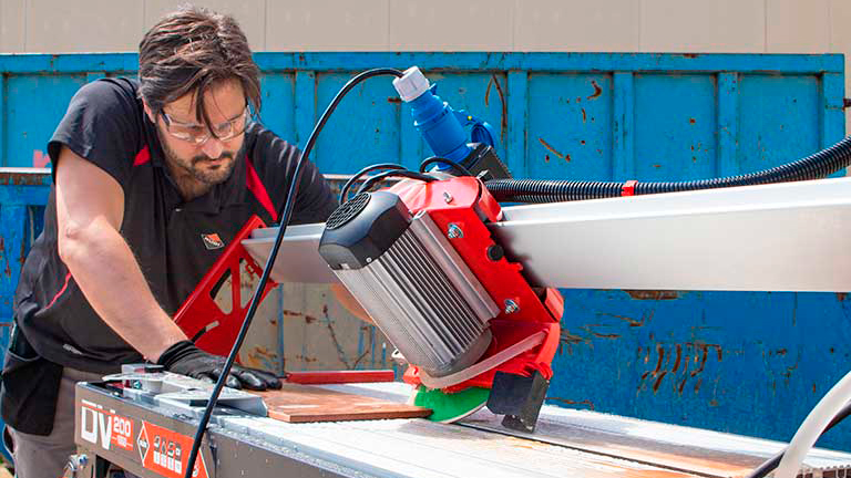 Tiler using a large bridge saw.