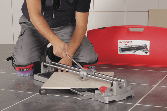 person using a tile cutter