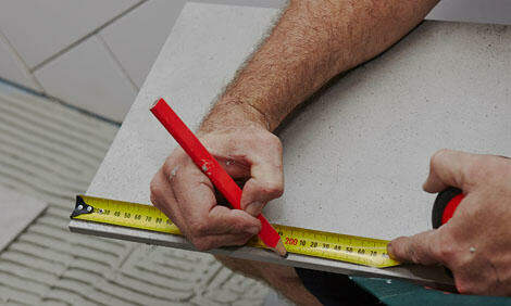 person measuring a ceramic floor tile