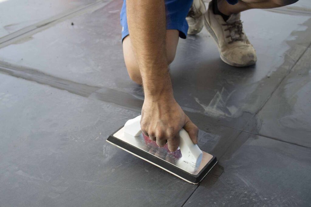person using epoxy grout