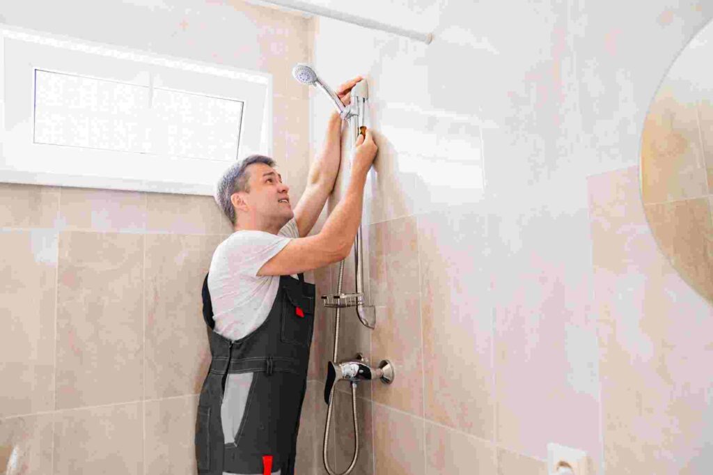 Tiler installing a shower after cutting a hole into tile. 